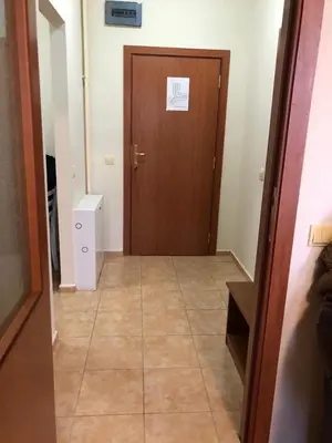 a hallway with a brown door and a tile floor at Flora Apartment 612A in Borovets