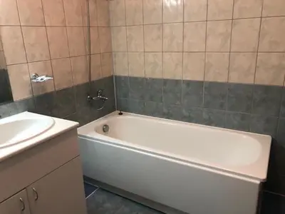 a bathroom with a white bath tub next to a sink at Flora Apartment 612A in Borovets