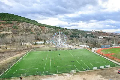 a ferris wheel in a park with a green field at Dream Park Apartment in Sandanski