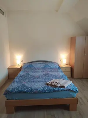 a bedroom with a blue bed with two lamps on the sides at BOROVETS Royal Plaza - A409 in Borovets