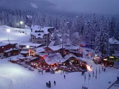 a ski resort in the snow at night at BOROVETS Royal Plaza - A409 in Borovets