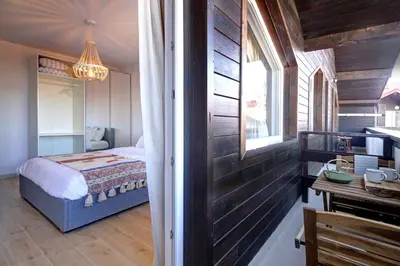 a bedroom with a bed and a table and a window at Pinewood Apartment Borovets in Borovets