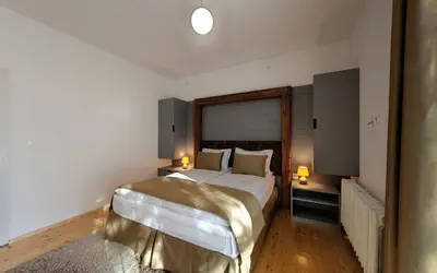 a bedroom with a large bed and two lamps at ШАЛЕТ БЕАТРИС in Razlog