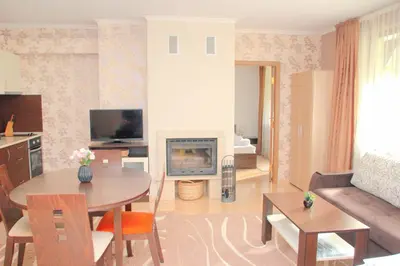 a living room with a table and a fireplace at Гранд Манастира Апартаменти 