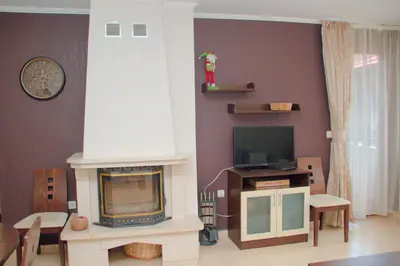 a living room with a fireplace and a tv at Гранд Манастира Апартаменти 