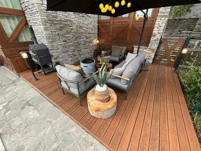 a wooden deck with furniture and an umbrella at Katarino Spa Chalet in Razlog