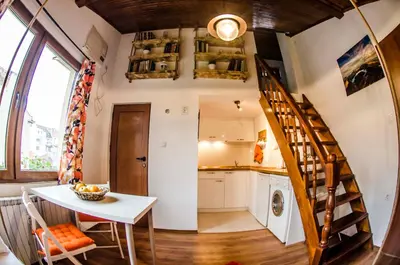 a kitchen with a staircase and a table in a room at Off Vitosha Blvd Designer Studio in Sofia