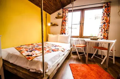 a bedroom with a swing bed and a table at Off Vitosha Blvd Designer Studio in Sofia