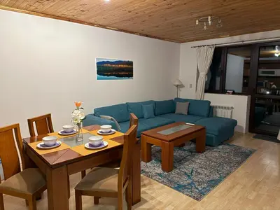 a living room with a blue couch and a table at Pamporovo Rhodopi Pearl Apartments - Private Apartments in Pamporovo