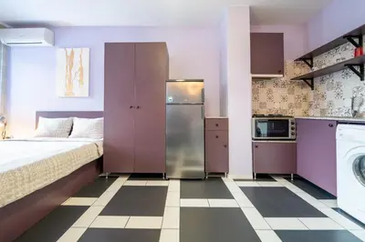 a small apartment with a bed and a washer and dryer at Spacious apartment in the heart of Studentski grad in Sofia