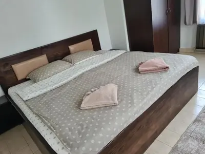 a large bed with two pink pillows on it at Мальовица - къща за гости in Dospey Makhala