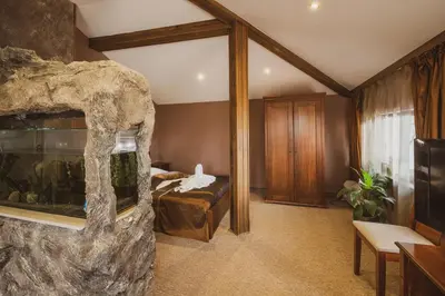 a room with a fish tank and a bedroom at Хотел Том и Нези Класик in Velingrad