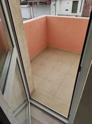 an empty balcony with an orange wall and a tile floor at BeLApartment in Petrich