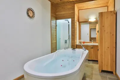 a large white tub in a bathroom with a sink at Luxury Chalets Pirin Golf & Country Club in Bansko