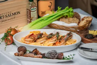 a table with a plate of food with shrimp and mushrooms at Luxury Chalets Pirin Golf & Country Club in Bansko