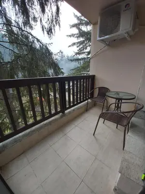 a balcony with two chairs and a table and a fan at Apartment Krasi in Velingrad