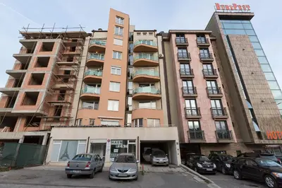 a tall building with cars parked in a parking lot at Studio Talisman III in Sofia