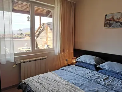 a bedroom with a bed and a window with a view at **Mountain** views just next to the gondola lift in Bansko