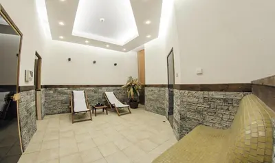 a lobby with two chairs and a stone wall at Ски студио Снежанка в Грийн лайф Пампорово in Pamporovo