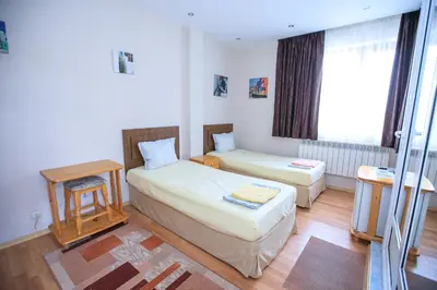 a small bedroom with two beds and a window at Guest House Amore in Sandanski