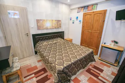 a small bedroom with a bed and a television at Guest House Amore in Sandanski