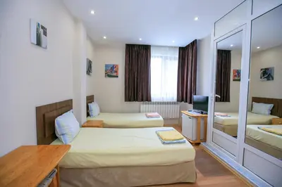 a hotel room with two beds and a desk at Guest House Amore in Sandanski
