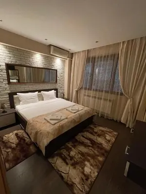 a bedroom with a large bed and a window at Guest House Amore in Sandanski