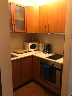 a small kitchen with wooden cabinets and a microwave at Ski Zone at Gondola, Perfect, Fast WiFi, Quiet, Warm in Bansko