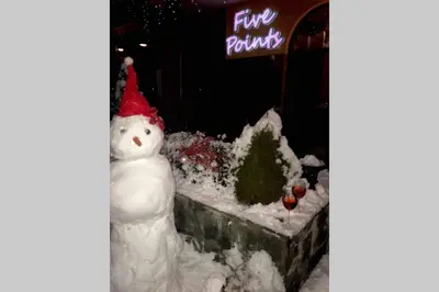 a snowman with a red hat sitting in the snow at Ski Zone at Gondola, Perfect, Fast WiFi, Quiet, Warm in Bansko