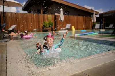 a little girl playing in a swimming pool at Guest house Wishmore in Banya