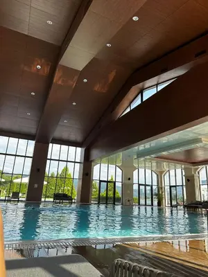 a large swimming pool in a building with windows at K's Place Apartment Pravets Golf Resort in Pravets