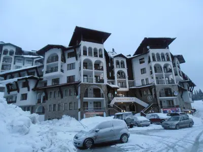 a group of buildings with cars parked in the snow at Monastery 3 Apartments TMF in Pamporovo
