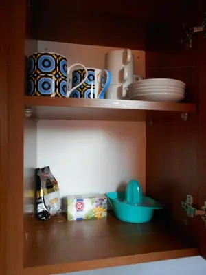 a cupboard with plates and bowls on a shelf at Studio Villa Park 408 in Borovets