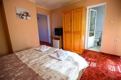 a bedroom with a bed and a wooden cabinet at Family Hotel Chichin in Bansko