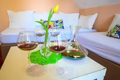 three glasses of wine on a table in a hotel room at Family Hotel Chichin in Bansko