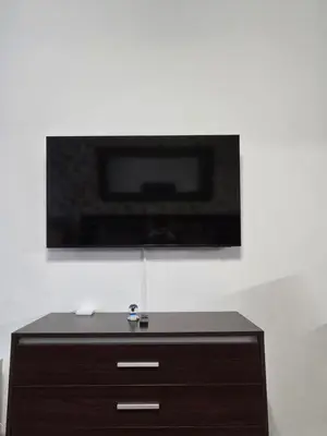 a tv on a white wall with a wooden dresser at Studio 1 Iceberg Borovets in Borovets