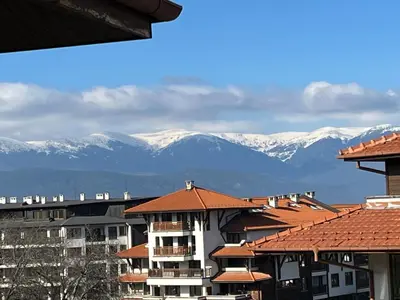 a group of buildings with snow covered mountains in the background at Ski Zone at Gondola, Warm and Cosy, WiFi, AC, Netflix, Perfect One Bedroom appartment, Beautiful View in Bansko