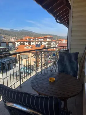 a wooden table and chairs on a balcony at Paradise dreams Velingrad in Velingrad