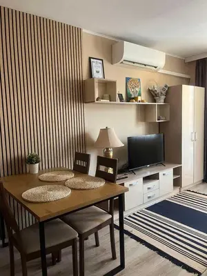 a dining room table with chairs and a television at Paradise dreams Velingrad in Velingrad