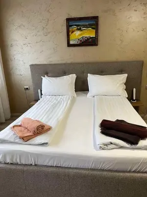 a large bed with two pillows and towels on it at Paradise dreams Velingrad in Velingrad