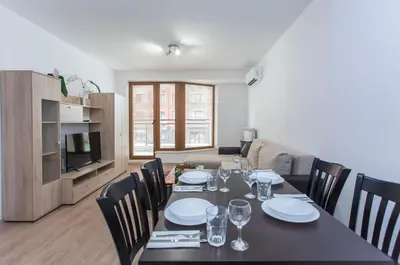 a dining table and chairs in a living room at Modern and Bright Apartments near Center - FREE PARKING in Sofia