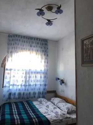 a bedroom with a bed and a window at Лилянината къща in Kalofer