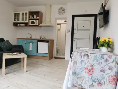 a living room with a table and a kitchen at Retro Studio byPMM in Plovdiv