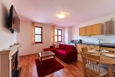 a living room with a red couch and a table at Mountain View Aparthotel in Bansko