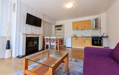 a living room with a purple couch and a table at Mountain View Aparthotel in Bansko