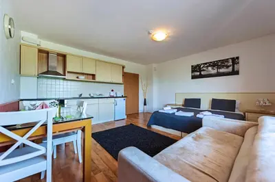 a living room with a couch and a kitchen at Mountain View Aparthotel in Bansko