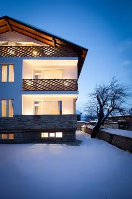 a building with snow in front of it at Къщи за гости Сноуфлейк Snowflake Chalet and Snowflake Lodge in Bansko