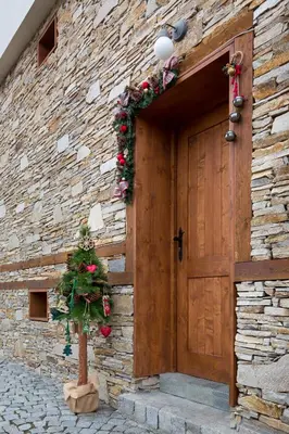 a door of a stone building with a christmas wreath at Къщи за гости Сноуфлейк Snowflake Chalet and Snowflake Lodge in Bansko