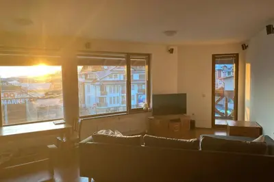 a living room with a couch and a flat screen tv at Large Gondola Apartment - Center, Neon in Bansko