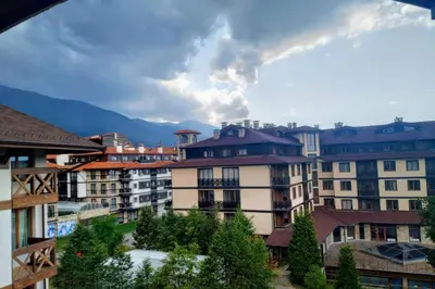 a group of buildings with mountains in the background at Large Gondola Apartment - Center, Neon in Bansko